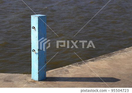Concrete pole with chains hooks on jetty, Blue Jetty pole, Blue concrete pier pillars with sunlight. Concrete pole with chains hooks on jetty, Blue Jetty pole, Blue concrete pier pillars with sunlight. 95504723