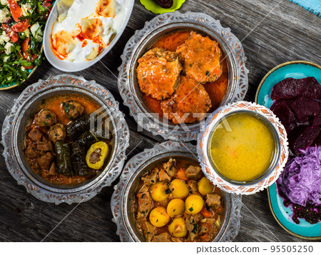 Eid Mubarak Traditional Ramadan Iftar dinner. Assorted tasty food in authentic rustic dishes on wooden blue background. Turkish Bosnian food meat kebab, pita, Sarma, klepe, sogan dolma. Eid Mubarak Traditional Ramadan Iftar dinner. Assorted tasty food in authentic rustic dishes on wooden blue background. Turkish Bosnian food meat kebab, pita, Sarma, klepe, sogan dolma. 95505250