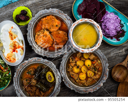 Eid Mubarak Traditional Ramadan Iftar dinner. Assorted tasty food in authentic rustic dishes on wooden blue background. Turkish Bosnian food meat kebab, pita, Sarma, klepe, sogan dolma. Eid Mubarak Traditional Ramadan Iftar dinner. Assorted tasty food in authentic rustic dishes on wooden blue background. Turkish Bosnian food meat kebab, pita, Sarma, klepe, sogan dolma. 95505254
