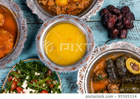 Eid Mubarak Traditional Ramadan Iftar dinner. Assorted tasty food in authentic rustic dishes on wooden blue background. Turkish Bosnian food meat kebab, pita, Sarma, klepe, sogan dolma. Eid Mubarak Traditional Ramadan Iftar dinner. Assorted tasty food in authentic rustic dishes on wooden blue background. Turkish Bosnian food meat kebab, pita, Sarma, klepe, sogan dolma. 95505314