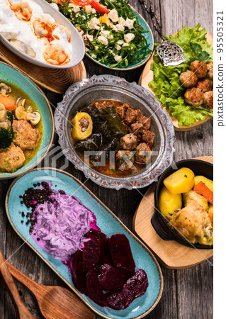 Eid Mubarak Traditional Ramadan Iftar dinner. Assorted tasty food in authentic rustic dishes on wooden blue background. Turkish Bosnian food meat kebab, pita, Sarma, klepe, sogan dolma. Eid Mubarak Traditional Ramadan Iftar dinner. Assorted tasty food in authentic rustic dishes on wooden blue background. Turkish Bosnian food meat kebab, pita, Sarma, klepe, sogan dolma. 95505321