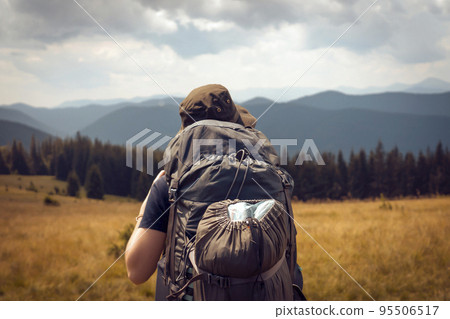 Young girl in a hat is trekking, hiking in the mountains. Young girl in a hat is trekking, hiking in the mountains. 95506517