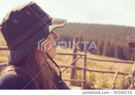 Happy young girl in a hat enjoys a village life. Happy young girl in a hat enjoys a village life. 95506519