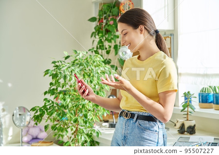 Teenage girl using smartphone for video call, room at home Teenage girl using smartphone for video call, room at home 95507227