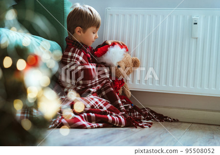 cute little boy wrapped id plaid sitting by heater cute little boy wrapped id plaid sitting by heater 95508052