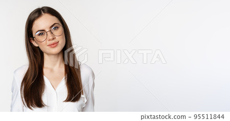 Close up portrait of smiling girl entrepreneur, office woman in glasses, looking happy and confident, standing in white blouse over studio background 95511844