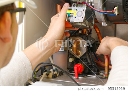 Technician servicing or Repair of a gas boiler, setting up and servicing. gas boiler for heating 95512939
