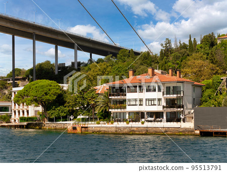 Traditional waterfront house, under Bosphorus bridge, and green hill with dense trees, Istanbul, Turkey Traditional waterfront house, under Bosphorus bridge, and green hill with dense trees, Istanbul, Turkey 95513791