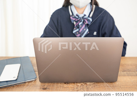 A female student wearing a computer and a mask 95514556