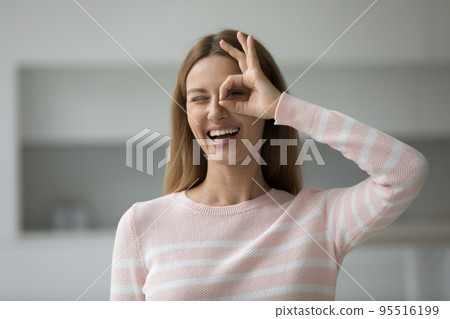 Head shot portrait smiling woman showing binocular shape with fingers Head shot portrait smiling woman showing binocular shape with fingers 95516199