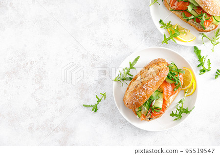 Sandwiches with salted salmon, arugugla and cucumber. Breakfast. Top view 95519547