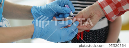Doctor use lancet on patient finger to check blood sugar level by glucose meter 95520564