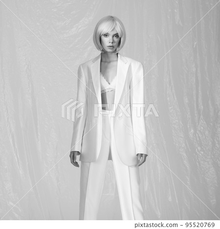 Studio fashion photo of young elegant woman in white men's jacke 95520769