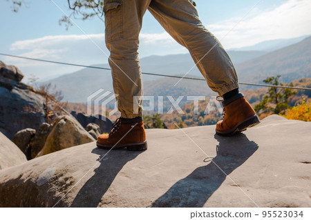 hiking concept men legs in boots on the rock hiking concept men legs in boots on the rock 95523034