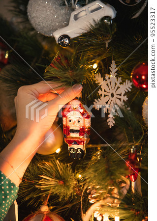 woman hand holding nutcracker christmas tree toy decoration woman hand holding nutcracker christmas tree toy decoration 95523317