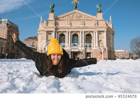 happy woman traveler in front of opera building in lviv city 95524078