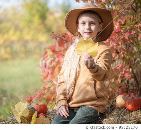 Girl in the hay with pumpkins 95525170