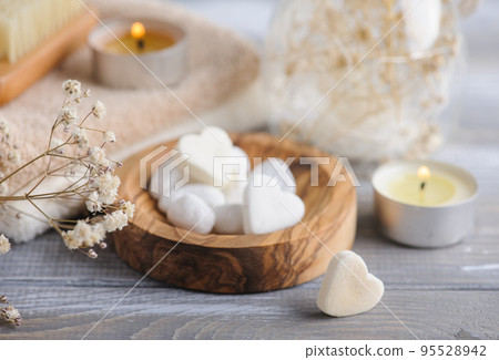 Bath bombs with dry flowers and lit candles 95528942