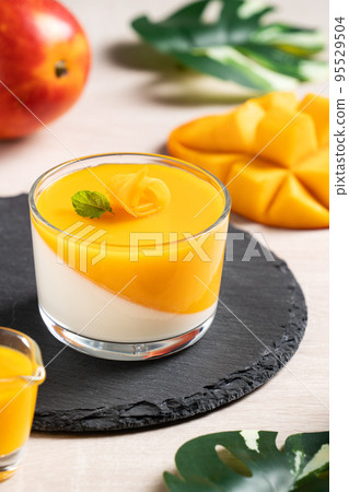 Delicious double colored mango panna cotta mousse pudding on wooden table background. 95529504