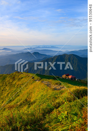 Tanigawa mountain range and Katano-koya mountain hut dyed in the morning glow 95530648
