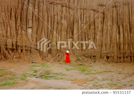 Women and landscape of soil textures eroded sandstone pillars, columns and cliffs, natural erosion of water and wind, Sao Din Na Noi, Hom Chom, Khok Suea at sri nan national park in Nan Province. 95531137
