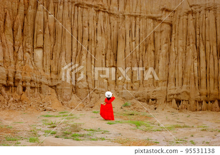 Women and landscape of soil textures eroded sandstone pillars, columns and cliffs, natural erosion of water and wind, Sao Din Na Noi, Hom Chom, Khok Suea at sri nan national park in Nan Province. 95531138
