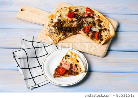 Pizza with bacon, beef forcemeat, onion, cherry tomatoes and mozzarella. 95531512
