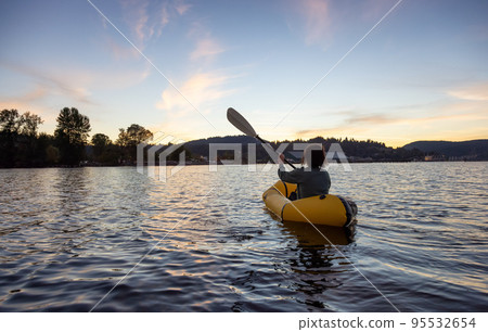 Adventurous Woman Kayaking on an Inflatable Kayak in the Pacific Ocean. Sunset Sky Adventurous Woman Kayaking on an Inflatable Kayak in the Pacific Ocean. Sunset Sky 95532654