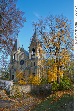 Old ancient church of Our Lady of the Holy Rosary and Saint Dominic in an autumn landscape. Rakov, Minsk region, Belarus. 95534742