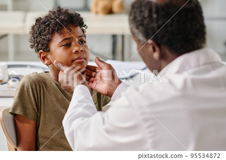 African little boy visiting pediatrician at hospital, he complaining on his sore throat African little boy visiting pediatrician at hospital, he complaining on his sore throat 95534872