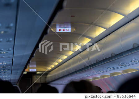 Exit sign in passenger airplane. Emergency exit sign on airplane. Exit airplane sign 95536644