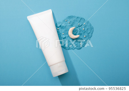 Cosmetology product for night facial care. Mockup white Cosmetic tube and plasticine modeling clay moon and stars on blue background. Skincare, moisturizing beauty, unbranded lotion, toothpaste, cream 95536825