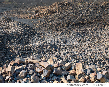 Basalt quarry. Marks of excavator operating in a rock quarry. Basalt quarry. Marks of excavator operating in a rock quarry. 95537898