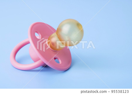 Orthodontic pacifier on a blue background. Pink baby pacifier 95538123