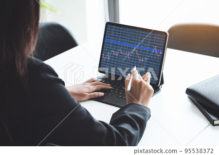 digital technology, Business woman using tablet to trade charts to find buy and sell points for her port digital technology, Business woman using tablet to trade charts to find buy and sell points for her port 95538372