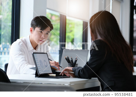 Two young business executives are discussing to change their business concept to increase profits and the strength of their business 95538481