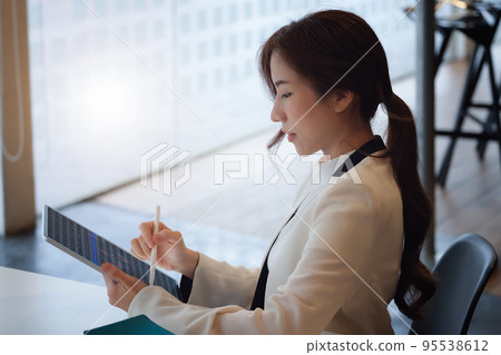 digital technology, Business woman using tablet to trade charts to find buy and sell points for her port 95538612