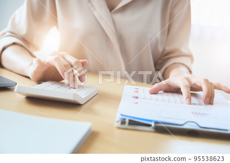 Business woman using calculator to review balance sheet annual using document and laptop computer to calculating budget. audit and Check integrity before investment concept. 95538623