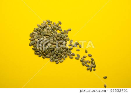 Pumpkin seed on a yellow background close-up. 95538791