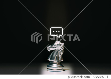 A chess piece of a horse with a message icon above it. Concept of communication and HR. 95539291