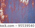 An old metal shield is painted gray with rust and cracks. 95539540