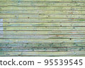 Old wooden painted green shield with cracks and scratches. 95539545