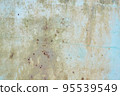 An old metal shield is painted gray with rust and cracks. 95539549
