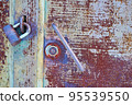Old metal door painted with gray paint with rust and cracks close-up. 95539550