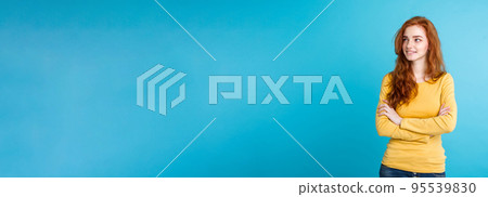 Lifestyle concept - Close up Portrait young beautiful attractive ginger red hair girl playing with her hair with shyness. Blue Pastel Background. Copy space. 95539830