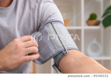 A man measures blood pressure with a white 95540152
