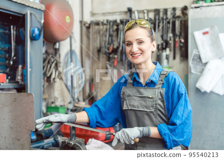 Female worker in metal workshop looking at camera 95540213