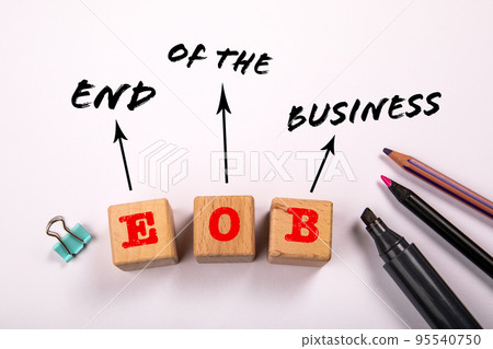 EOB- End Of the Business. Wooden blocks on a white office table EOB- End Of the Business. Wooden blocks on a white office table 95540750