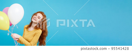 Celebrating Concept - Close up Portrait happy young beautiful attractive redhair girl smiling with colorful party balloon. Blue Pastel Background. Celebrating Concept - Close up Portrait happy young beautiful attractive redhair girl smiling with colorful party balloon. Blue Pastel Background. 95541428