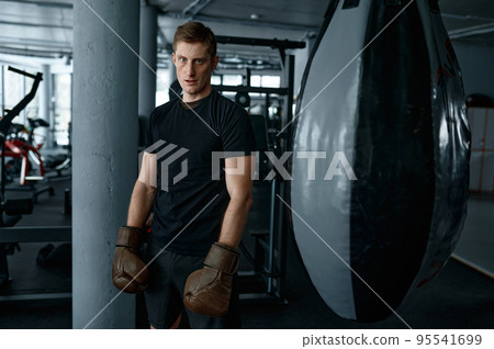 Tired boxer with masculine body in boxing gloves Tired boxer with masculine body in boxing gloves 95541699